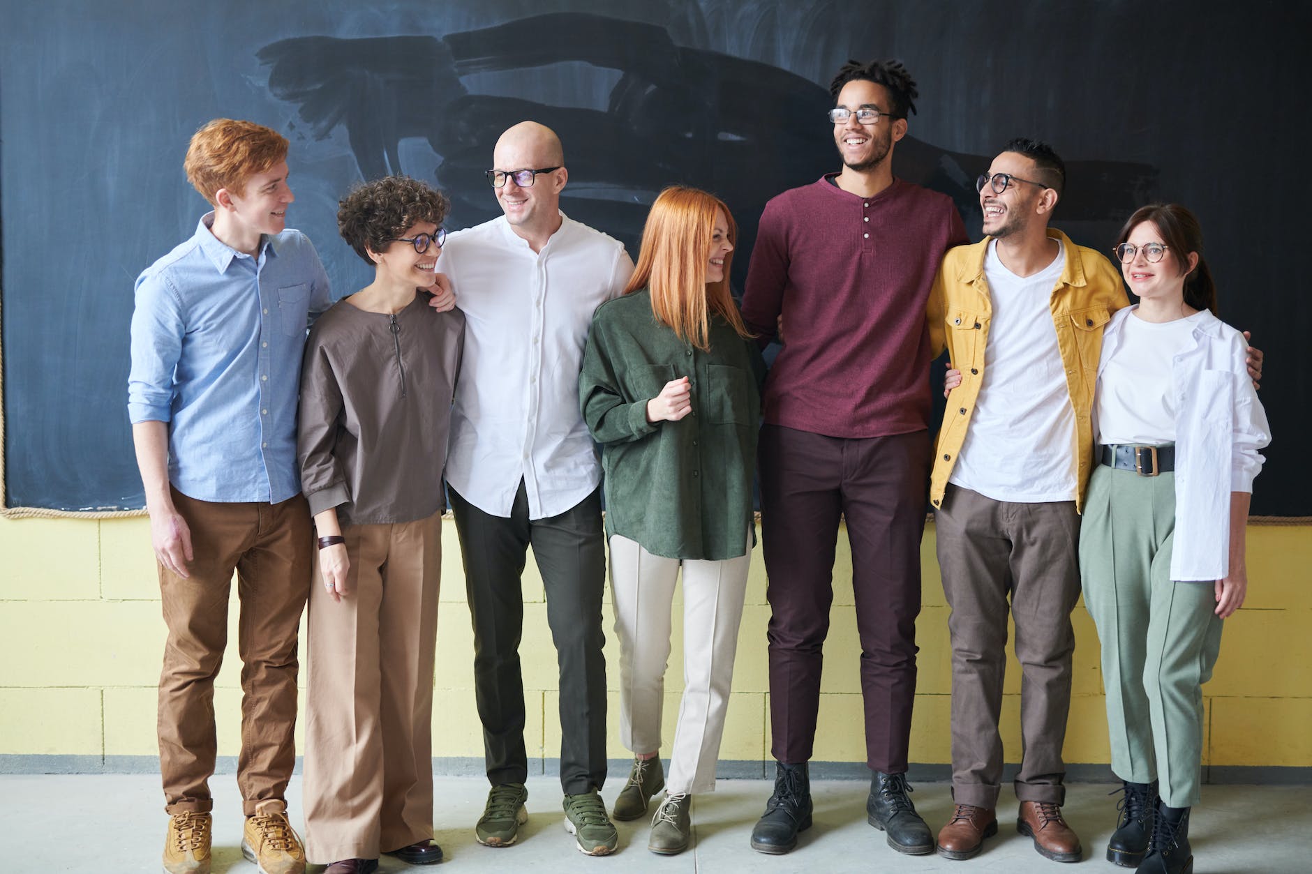 Group of diverse teachers tanding in front of a chalkboard